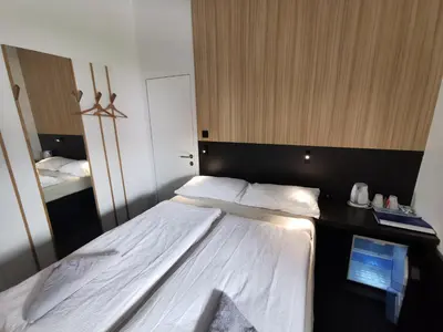a bedroom with a large bed with a black headboard at Cha Cha Rooms in Ljubljana