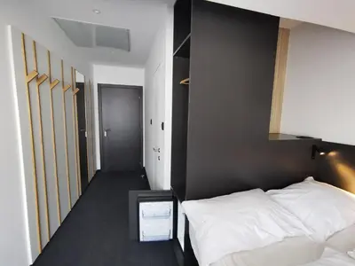 a bedroom with two white beds and a black wall at Cha Cha Rooms in Ljubljana