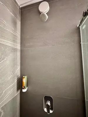 a bathroom with a shower with a sink and a toilet at Cha Cha Rooms in Ljubljana
