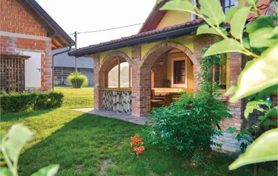 a brick house with a picnic table in the yard at Three-Bedroom Holiday Home In Gradac in Gradac