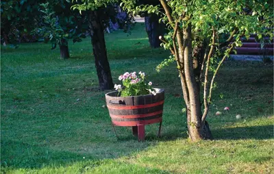 a planter with flowers in it next to a tree at Three-Bedroom Holiday Home In Gradac in Gradac