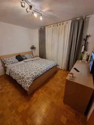 a bedroom with a bed and a wooden floor at Apartment Gulek in Zreče