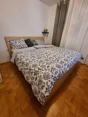 a bedroom with a bed with a black and white comforter at Apartment Gulek in Zreče