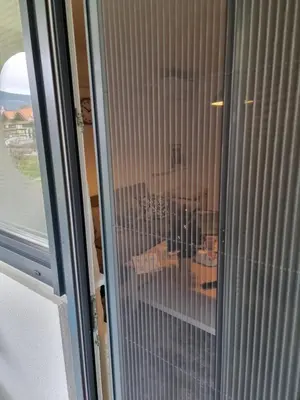 a glass door with a reflection of a table at Apartment Gulek in Zreče