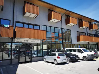 a building with cars parked in a parking lot at Apartment Viki in Kranjska Gora