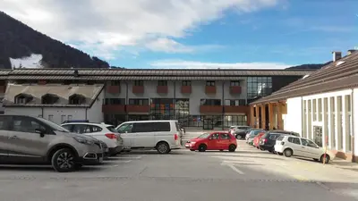 a parking lot with cars parked in front of a building at Apartment Viki in Kranjska Gora