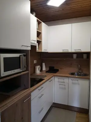 a kitchen with white cabinets and a microwave at Apartment Viki in Kranjska Gora