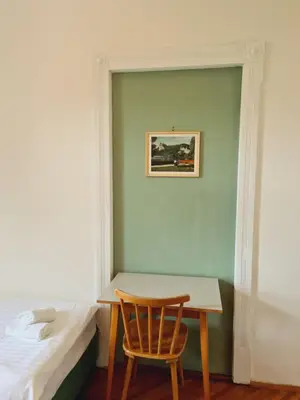 a bedroom with a table and a chair next to a bed at Vila Gorenka in Bled