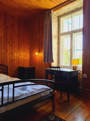 a bedroom with a bed and a desk and a window at Vila Gorenka in Bled
