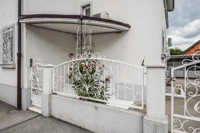a white balcony with a gate with flowers on it at Kavon Apartments in Ljubljana
