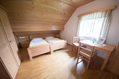 a bedroom with a bunk bed and a desk and a table at Tourist Farm Pr'Dovar in Cerklje na Gorenjskem
