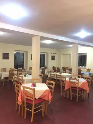 a dining room with tables and chairs with red table cloth at Youth Hostel Nika in Kranjska Gora
