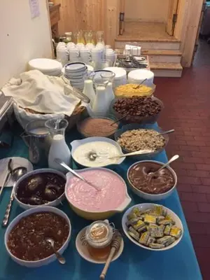 a blue table topped with bowls and plates of food at Youth Hostel Nika in Kranjska Gora