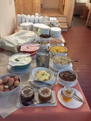 a table topped with bowls and plates of food at Youth Hostel Nika in Kranjska Gora