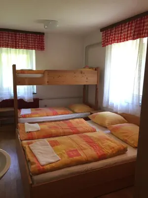 two bunk beds in a room with windows at Youth Hostel Nika in Kranjska Gora