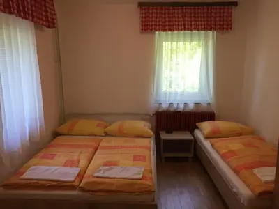 two beds in a small room with two windows at Youth Hostel Nika in Kranjska Gora
