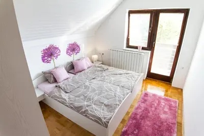 a bedroom with a large bed with purple pillows at D&J house in Ormoz