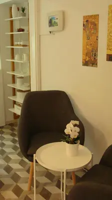 a living room with a chair and a table at Apartma Nadja with private parking in Ljubljana