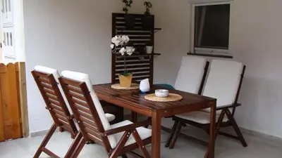 a dining room table with white chairs around it at Apartma Nadja with private parking in Ljubljana