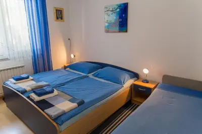 a bedroom with a bed with blue sheets and blue pillows at Apartma Groš in Kranjska Gora