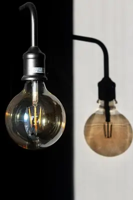 two lights are hanging on a wall at Apartma Vita in Dobrovo