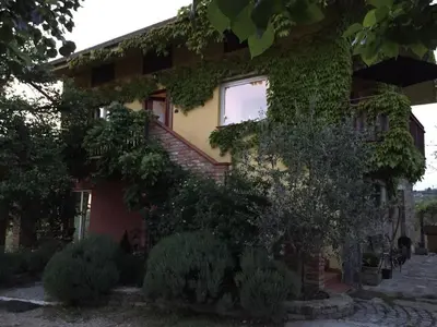 a house with ivy on the side of it at Apartma Vita in Dobrovo
