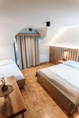 a hotel room with two beds and a table at Guesthouse Smogavc in Zreče