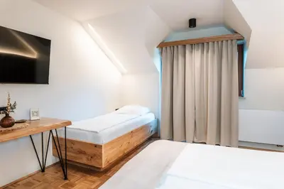a small room with a bed and a tv at Guesthouse Smogavc in Zreče
