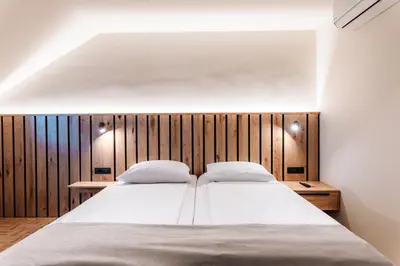 a bedroom with a large bed with a wooden headboard at Guesthouse Smogavc in Zreče