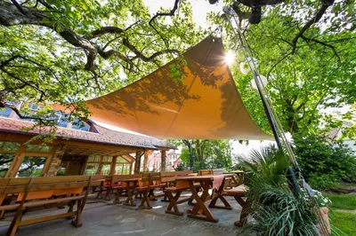 a picnic table with an umbrella in front of a building at Guesthouse Smogavc in Zreče