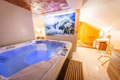 a large tub in a bathroom with a painting on the wall at Domačija Vodnik & Apartments in Cerklje na Gorenjskem