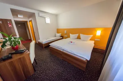 a hotel room with a bed and a desk at Domačija Vodnik & Apartments in Cerklje na Gorenjskem