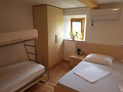 a small room with two bunk beds and a window at Domačija Vodnik & Apartments in Cerklje na Gorenjskem