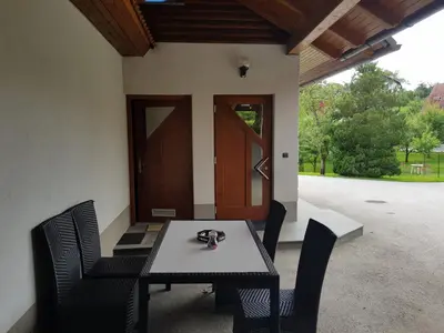 a table and chairs on the porch of a house at Domačija Vodnik & Apartments in Cerklje na Gorenjskem