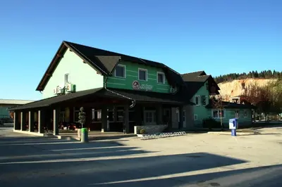 a building with a green roof on a street at Rooms En Krajcar in Cerknica