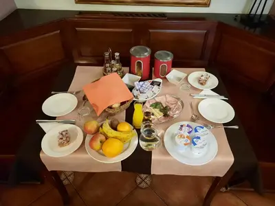 a table with plates of food and fruit on it at Rooms En Krajcar in Cerknica