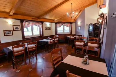 a restaurant with tables and chairs in a room at Rooms En Krajcar in Cerknica
