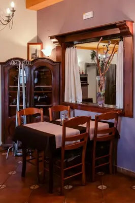 a dining room with a table and chairs and a mirror at Rooms En Krajcar in Cerknica
