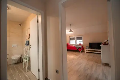 an open door to a living room with a red couch at Apartment Stil near Terme Paradiso in Dobova