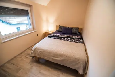 a small bedroom with a bed and a window at Apartment Stil near Terme Paradiso in Dobova
