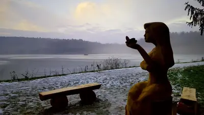a statue of a woman standing next to a bench at Glamping NA BREJGI in Filovci