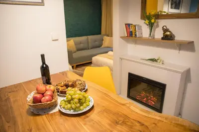 a table with two baskets of fruit and a bottle of wine at Apartment Artorius Ljubljana in Ljubljana