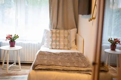 a bedroom with a bed with a window and two tables at Apartment Artorius Ljubljana in Ljubljana