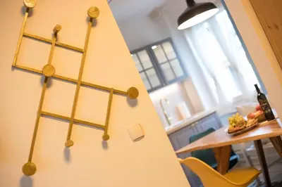 a clock on a wall in a room with a table at Apartment Artorius Ljubljana in Ljubljana