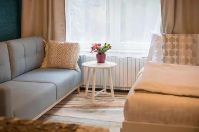 a living room with a couch and a table with flowers at Apartment Artorius Ljubljana in Ljubljana