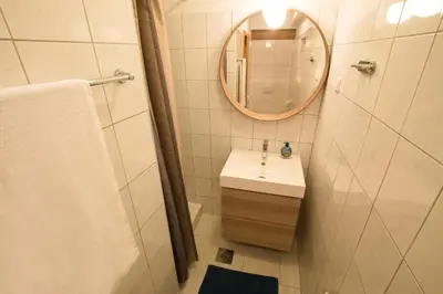a white bathroom with a sink and a mirror at Apartment Artorius Ljubljana in Ljubljana