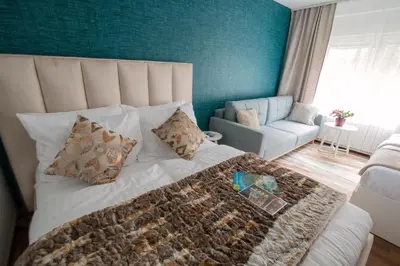 a bedroom with a bed and a couch and a chair at Apartment Artorius Ljubljana in Ljubljana