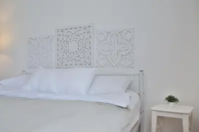 a white bedroom with a white bed with white pillows at Historic Mexico Building Apartment in Ljubljana