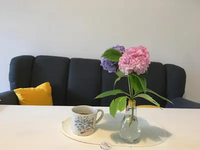 a vase with flowers and a cup of coffee on a table at Historic Mexico Building Apartment in Ljubljana
