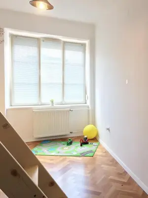 a white room with a childs toy on the floor at Historic Mexico Building Apartment in Ljubljana